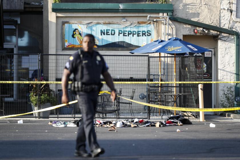 Shoes are piled outside the scene of a mass shooting including Ned Peppers bar, Sunday, Aug. 4, 2019, in Dayton, Ohio. Several people in Ohio have been killed in the second mass shooting in the U.S. in less than 24 hours, and the suspected shooter is also deceased, police said. (AP Photo/John Minchillo)