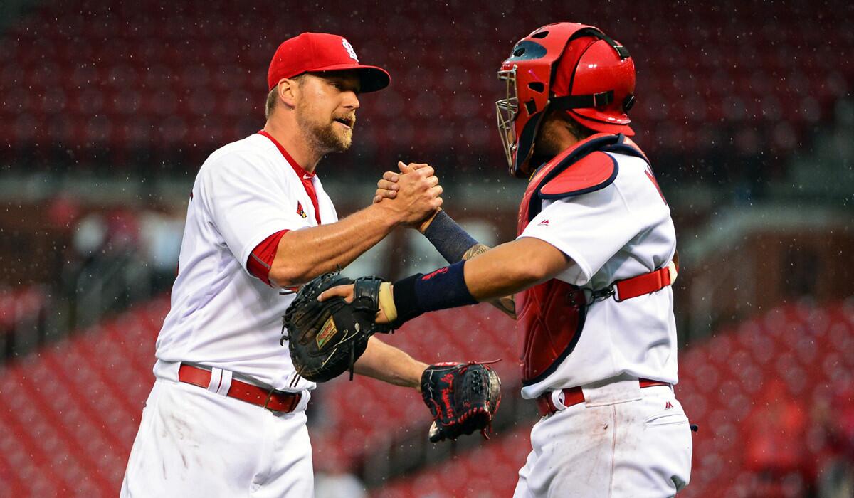 St. Louis Cardinals' Trevor Rosenthal, left, celebrates with Yadier Molina after closing out the ninth inning and recording his 100th career save against the Chicago Cubs on Wednesday.