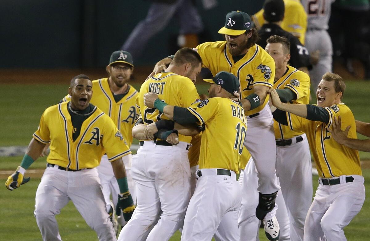 Oakland's Stephen Vogt, center left, celebrates with his teammates after driving in the winning run in the Athletics' victory over the Detroit Tigers in Game 2 of the American League division series Saturday.