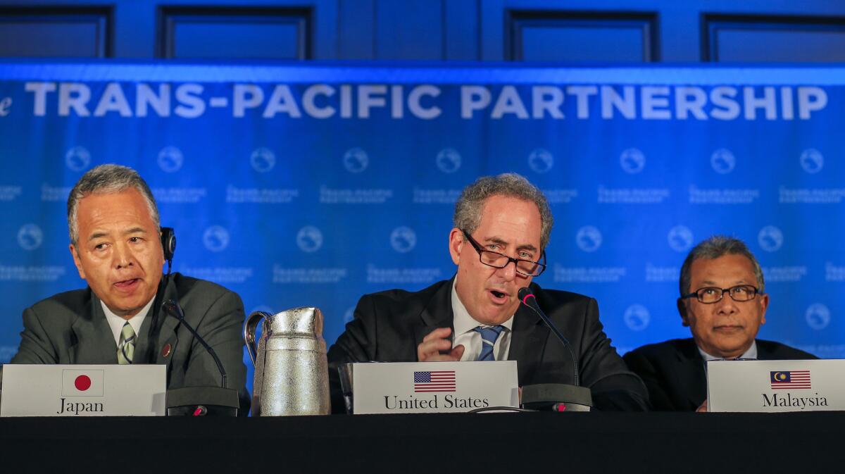 U.S. Trade Representative Michael Froman, center, is flanked by Japan's Trade Minister Akira Amari, left, and Malaysia's Trade Minister Mustapa Mohamed as he speaks after an agreement was reached in the Trans-Pacific Partnership.