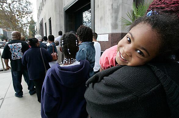 Kassidy Jackson, 3, is all smiles as she waits with her family that's in line to buy commemorative newspapers of Barack Obama's win. Visitors are continuing to line up outside the Los Angeles Times headquarters in downtown.