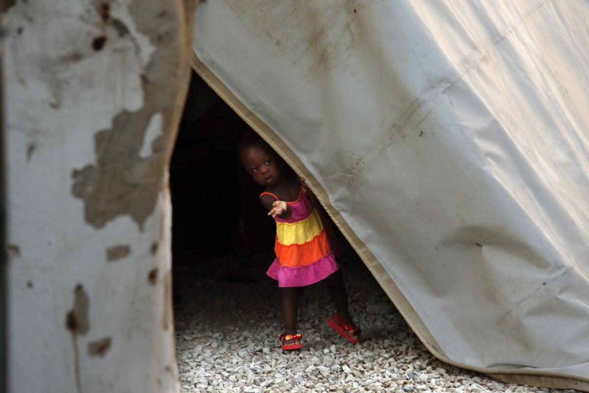 A Haitian child peers out of a tent where some families spend the day at the Desayunador Salesiano Padre Chava shelter in Tijuana, Mexico.