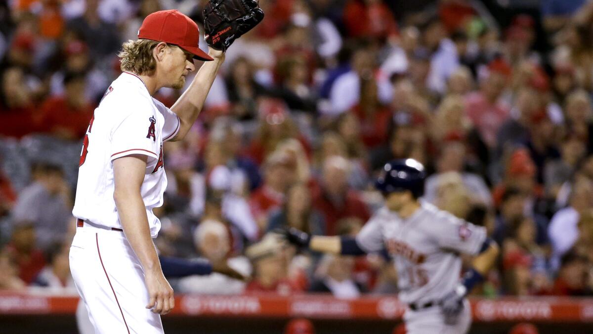 Angels starter Jered Weaver returns to the mound as he waits for Houston's Jason Castro to head home after hitting a two-run home run in the sixth inning Saturday.