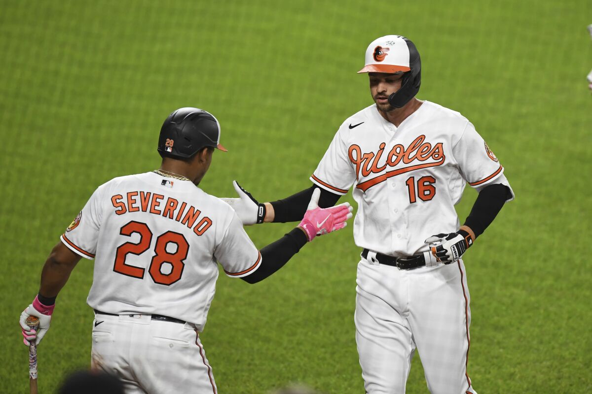 Baltimore Orioles Trey Mancini (16) is greeted by Pedro Severino (28) after hitting sixth inning solo home run during a baseball game Monday, May 10, 2021, in Baltimore. (AP Photo/Terrance Williams)