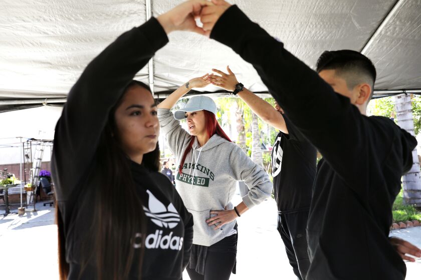 EL MONTE-CA-MARCH 22, 2020: Choreographer Cynthia Garcia, center, teaches dance to a group of youngsters for an upcoming quinceanera for Ashley Soltero, 14, left, in El Monte on Sunday, March 22, 2020. (Christina House / Los Angeles Times)