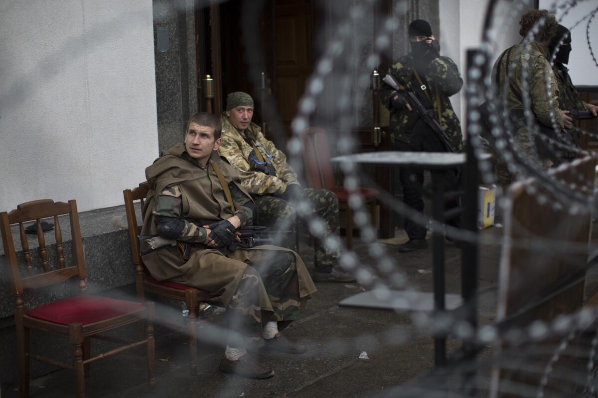 Pro-Russia gunmen guard an entrance to the administration building in Luhansk, an eastern Ukrainian city of 450,000, after seizing the government headquarters on Wednesday.