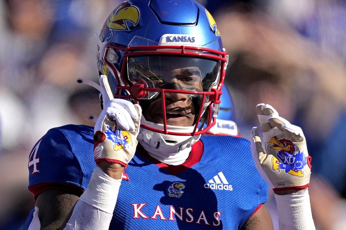 Kansas running back Devin Neal (4) celebrates after scoring a touchdown during the first half of an NCAA college football game against Oklahoma State Saturday, Nov. 5, 2022, in Lawrence, Kan. (AP Photo/Charlie Riedel)