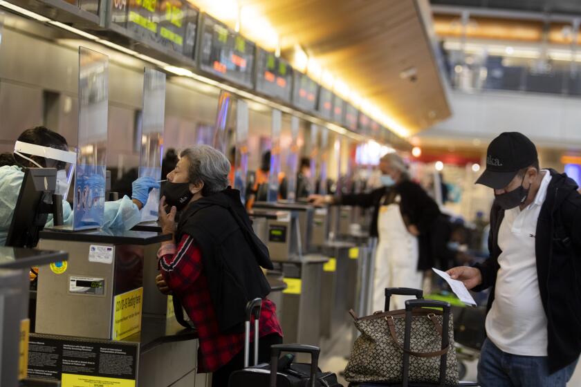 LOS ANGELES, CA - NOVEMBER 17: During the global coronavirus pandemic Ana Ramos is being tested for covid19 in Tom Bradley international at LAX on Tuesday, Nov. 17, 2020 in Los Angeles, CA. Los Angeles International Airport started issuing molecular or PCR tests this week and has plans to quickly expand the program in order to help detect coronavirus and slow its spread. (Francine Orr / Los Angeles )