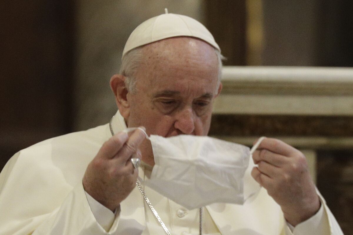 Pope Francis puts on a face mask at an Oct. 20 ecumenical service in Rome.