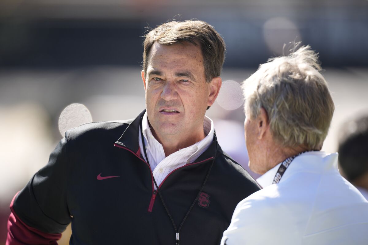 USC athletic director Mike Bohn, left, chats with Gary Barnett, former Colorado football coach before a game in October.