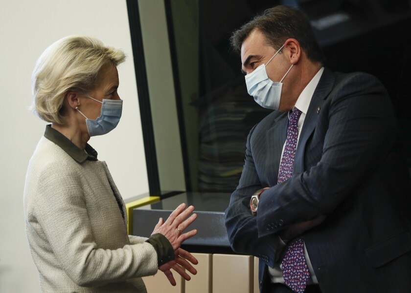 European Commission President Ursula von der Leyen speaks with European Way of Life Commissioner Margaritis Chinas, right, prior to the meeting of College of Commissioners, in Strasbourg, France, Tuesday, Dec. 14 2021. The College will discuss on a comprehensive package on energy and climate action and will also adopt a proposal for a revision of the Schengen Borders Code. (Julien Warnand, Pool Photo via AP)