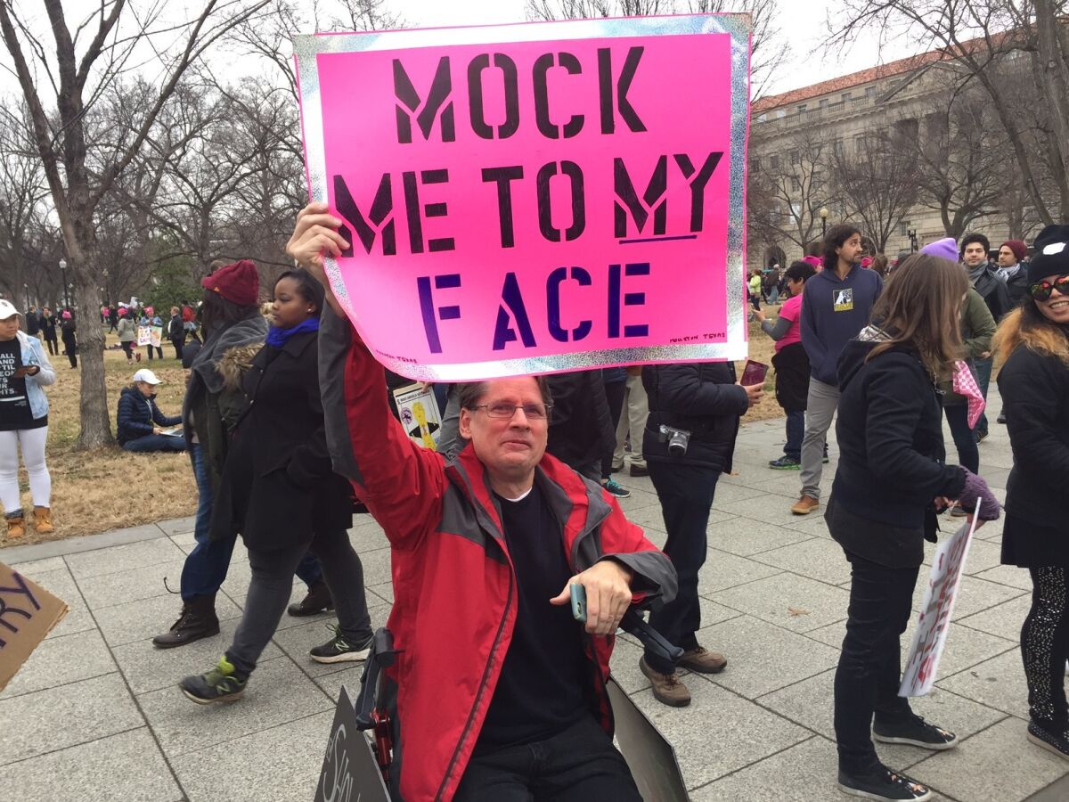 Among many placards on display, this one seemed especially personal. It alluded to then-candidate Trump's mocking imitation of a disabled journalist whose coverage he criticized.