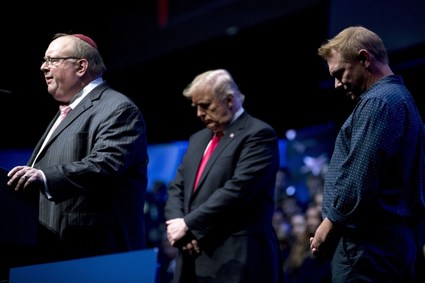 Rabbi Benjamin Sendrow, left, accompanied by President Donald Trump and the Rev. Thom O'Leary, prays at the 91st annual Future Farmers of America Convention and Expo at Bankers Life Fieldhouse in Indianapolis on Oct. 27, 2018, following a shooting in a Pittsburgh synagogue.