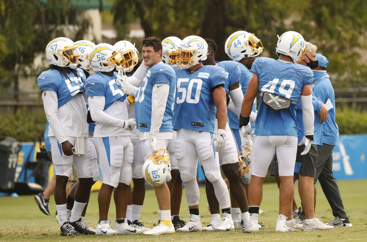 Chargers defensive players gather on the field at the Hammett Sports Complex in Costa Mesa on Monday.