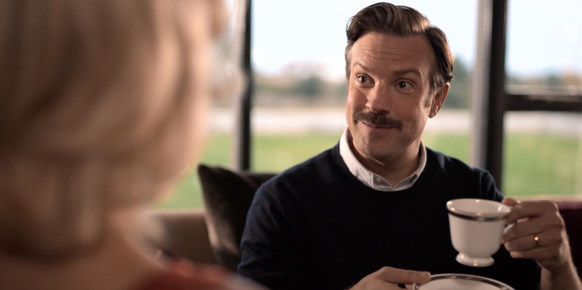 Jason Sudeikis holding a teacup in "Ted Lasso"