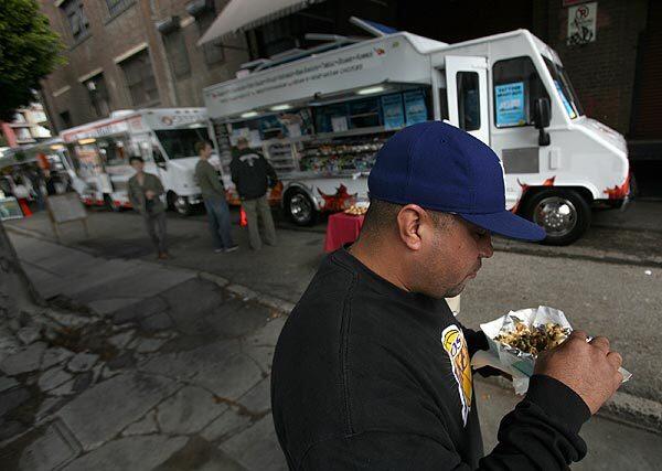 Eric Rivera, 41, of Downey eats a pulled-pork taco he purchased from a food truck near South Alameda Street and Traction Avenue in downtown Los Angeles. "I'll be back," he said.