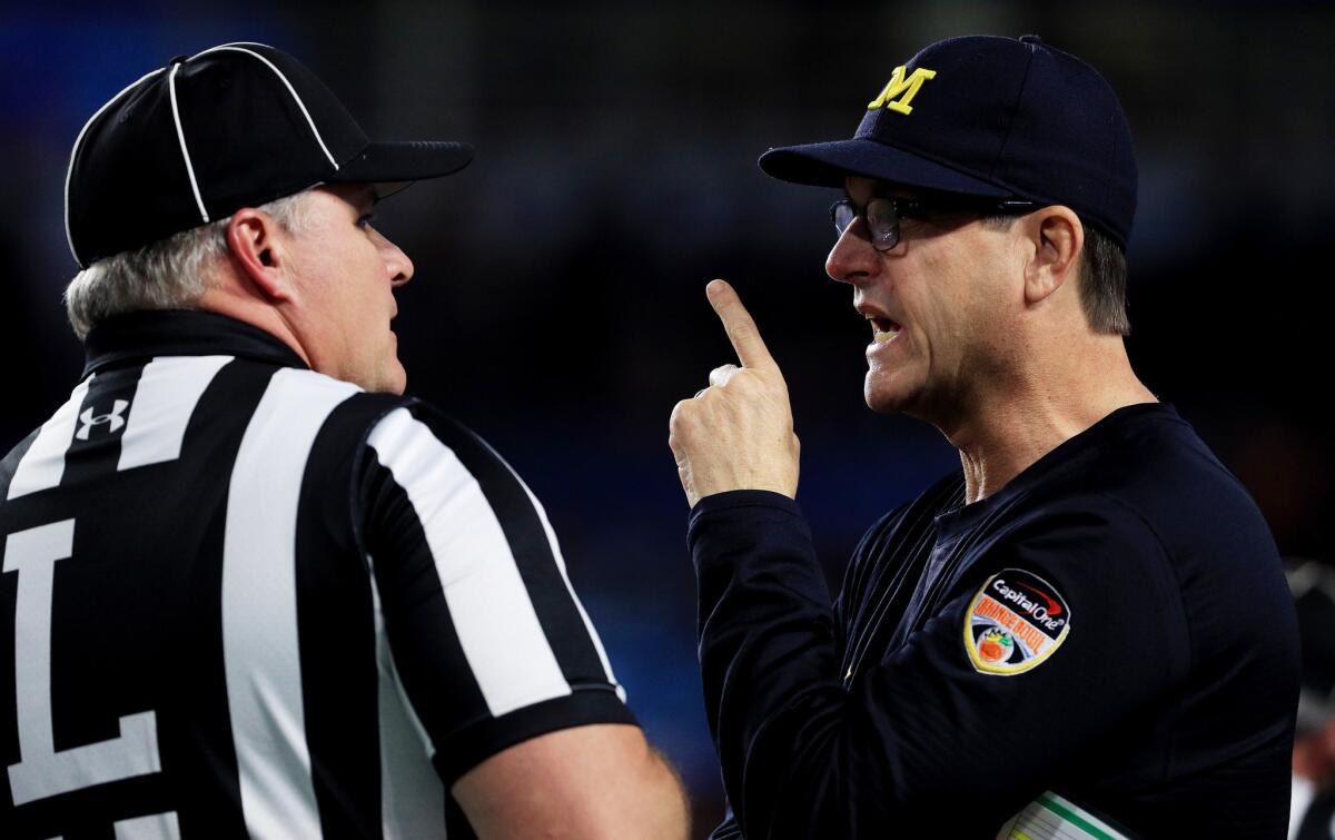 Michigan Coach Jim Harbaugh talks to a referee in the first half of the Orange Bowl against the Florida State Seminoles on Dec. 30 in Miami Gardens, Fla.