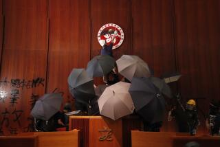 FILE - Protesters deface the Hong Kong logo at the Legislative Council to protest against the extradition bill in Hong Kong on July 1, 2019. A Hong Kong court sentenced 12 people Saturday, March 16, 2024 to prison over the storming of the city’s legislative council building at the height of the anti-government protests in 2019. (AP Photo/Vincent Yu, File)