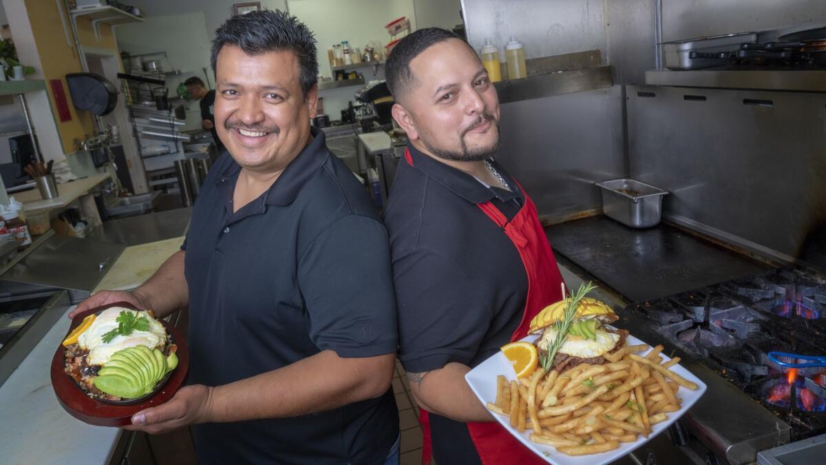 Mixing both of their Mexican and Pilipino heritages, Richard Corpus (l) and Roger Buhain (r) hold two of the popular dishes served at their new restaurant in Chula Vista, MexiPino Hash and the MexiPino Breakfast Sandwich.