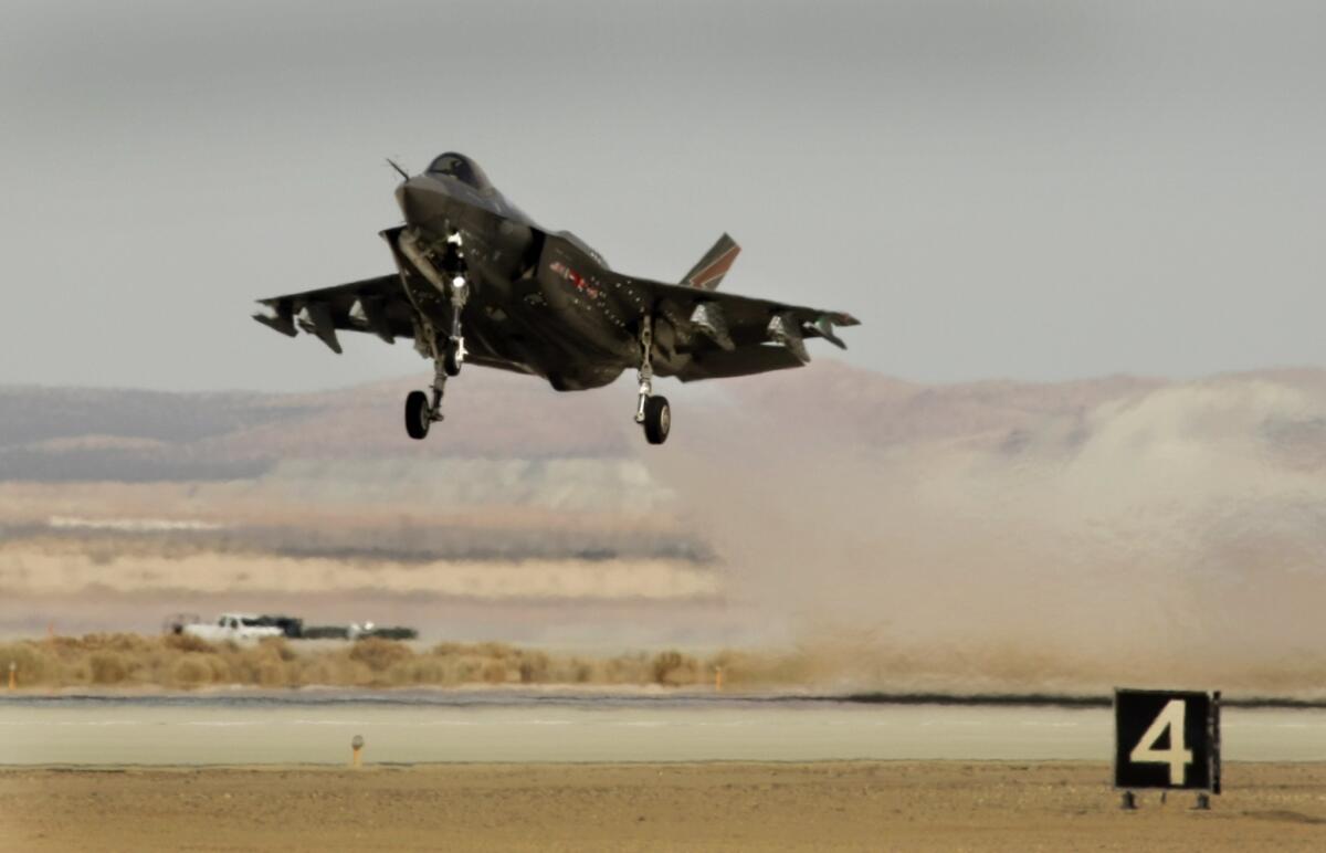 Lockheed Martin is cutting 4,000 positions and closing some plants due to reduced government defense spending, the firm said Thursday. Above, Lockheed Martin's F-35 Lightning II fighter jet during testing at Edwards Air Force Base in March.