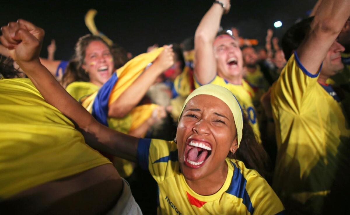 Ecuadorian soccer team fans react to their team scoring against the Honduras team as they watch on the screen setup at the Word Cup FIFA Fan Fest during on Copacabana beach June 2 in Rio de Janeiro, Brazil.