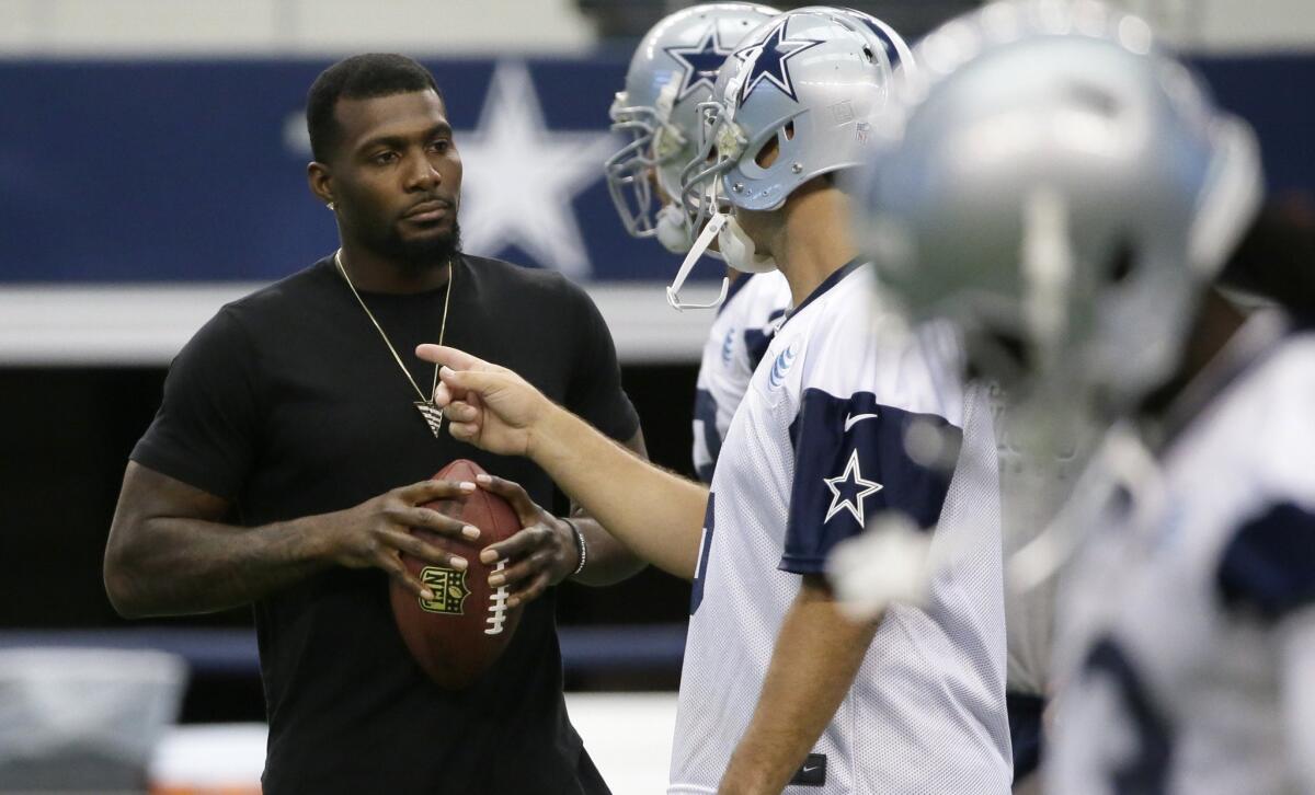 Dallas wide receiver Dez Bryant, left, listens to quarterback Tony Romo during a mini-camp on June 18.