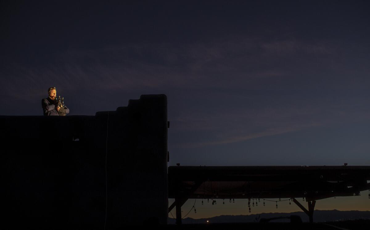 Matt Barbier greets the rising moon with bagpipes on the roof at the Creosote House in Joshua Tree as part of Wild Up's "Desert Moon," the opening concert in its "darkness sounding" series. 