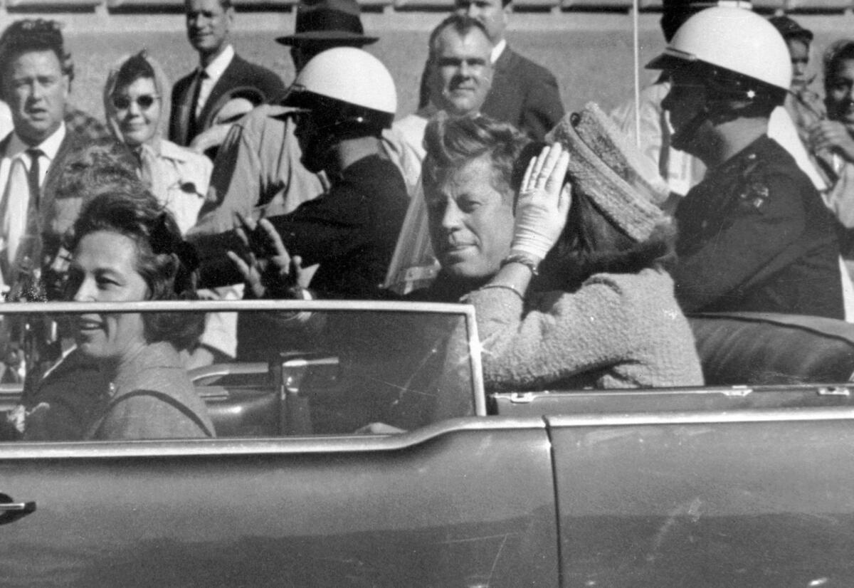 President John F. Kennedy waves from his car in a motorcade in Dallas just before being shot on Nov. 22, 1963.