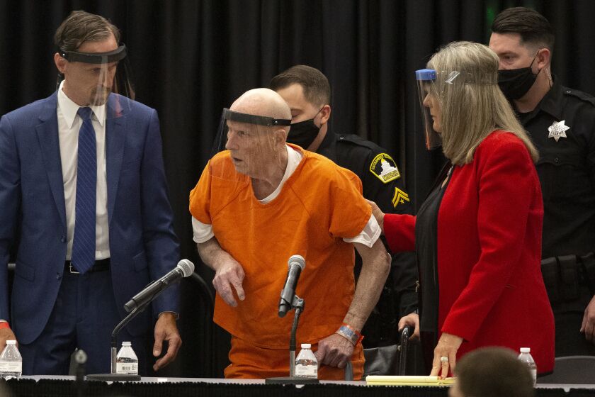 Joseph James DeAngelo, center, charged with being the Golden State Killer, is helped up by his attorney, Diane Howard, as Sacramento Superior Court Judge Michael Bowman enters the courtroom in Sacramento, Calif., Monday June 29, 2020. DeAngelo pleaded guilty to multiple counts of murder and other charges 40 years after a sadistic series of assaults and slayings in California. Due to the large numbers of people attending, the hearing was held at a ballroom at California State University, Sacramento to allow for social distancing. (AP Photo/Rich Pedroncelli)