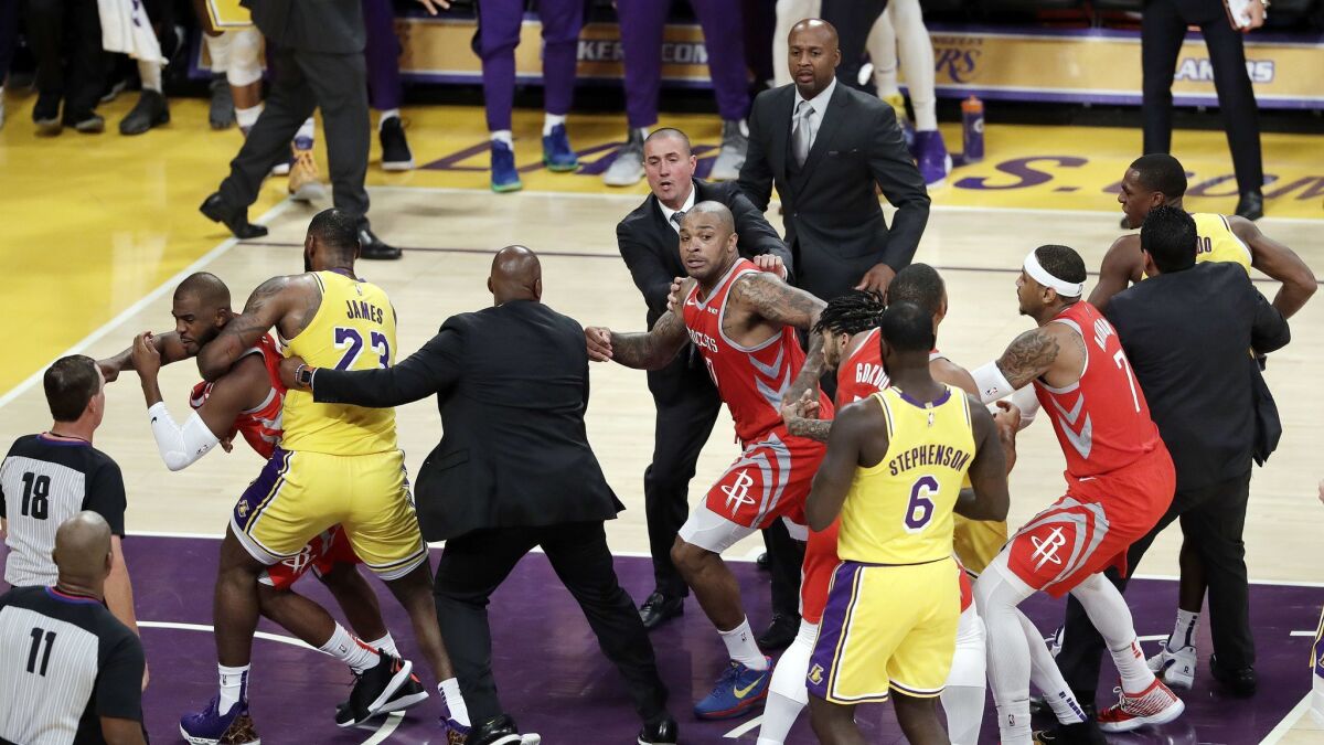 Houston's Chris Paul, far left, is held back by LeBron James after Paul fought with Rajon Rondo, far right, late in the Lakers' home opener.