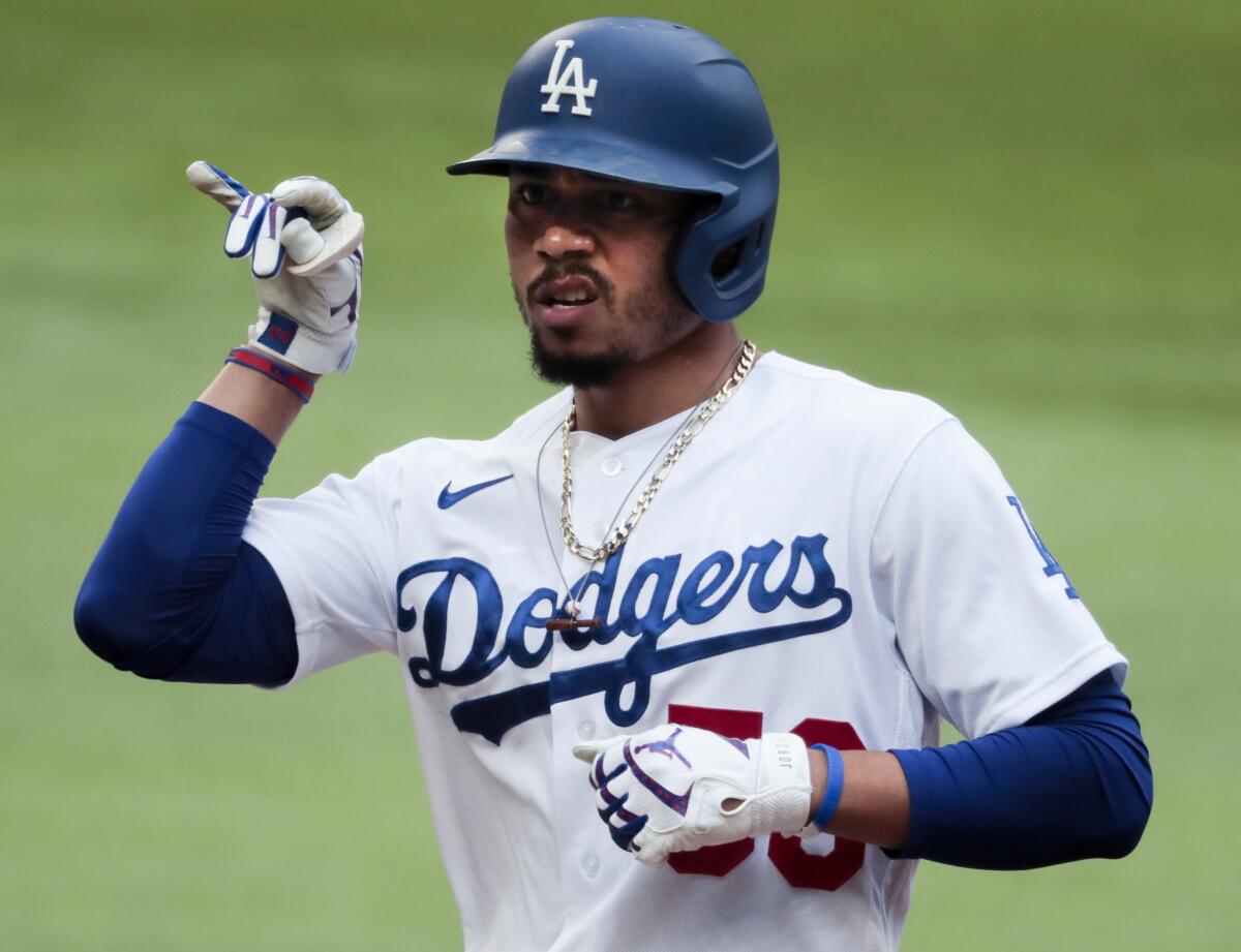 Dodgers right fielder Mookie Betts gestures to the dugout after hitting a second-inning single in Game 6.