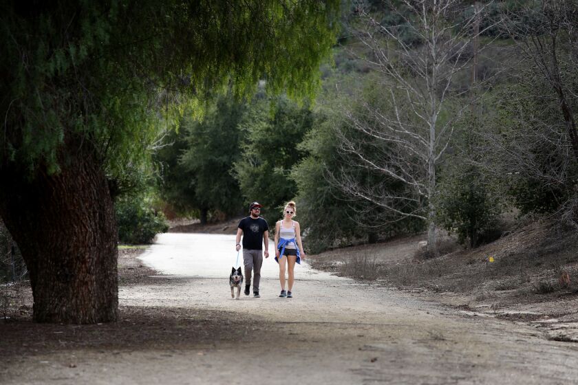 Mentryville, site of Southern California's first commercial oil well, is now a park. Marco Negovschi, Julia Hause and Roo the dog walk the Pico Canyon trail into the park.