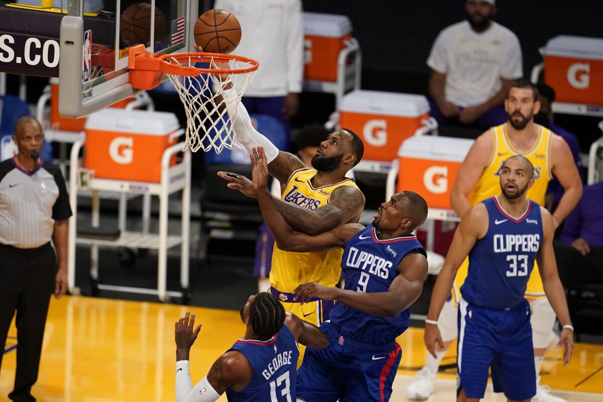 Lakers forward LeBron James drives to the basket over Clippers center Serge Ibaka.