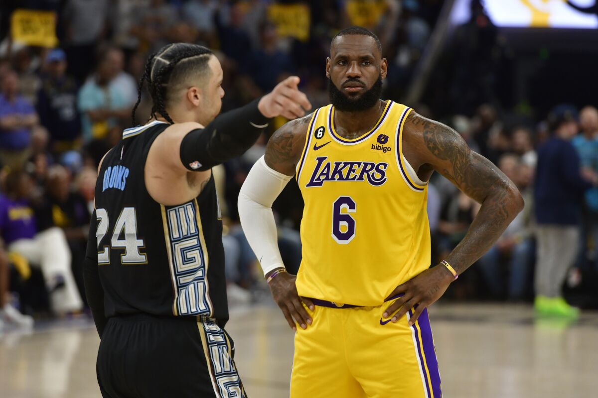 Grizzlies forward Dillon Brooks, left, points to his right as he has a few words for Lakers forward LeBron James.