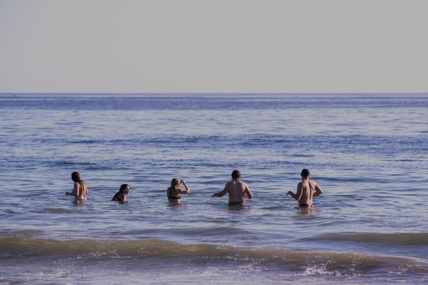 People standing in waist-high ocean water.