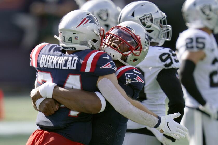 New England Patriots quarterback Cam Newton, right, gives running back Rex Burkhead.