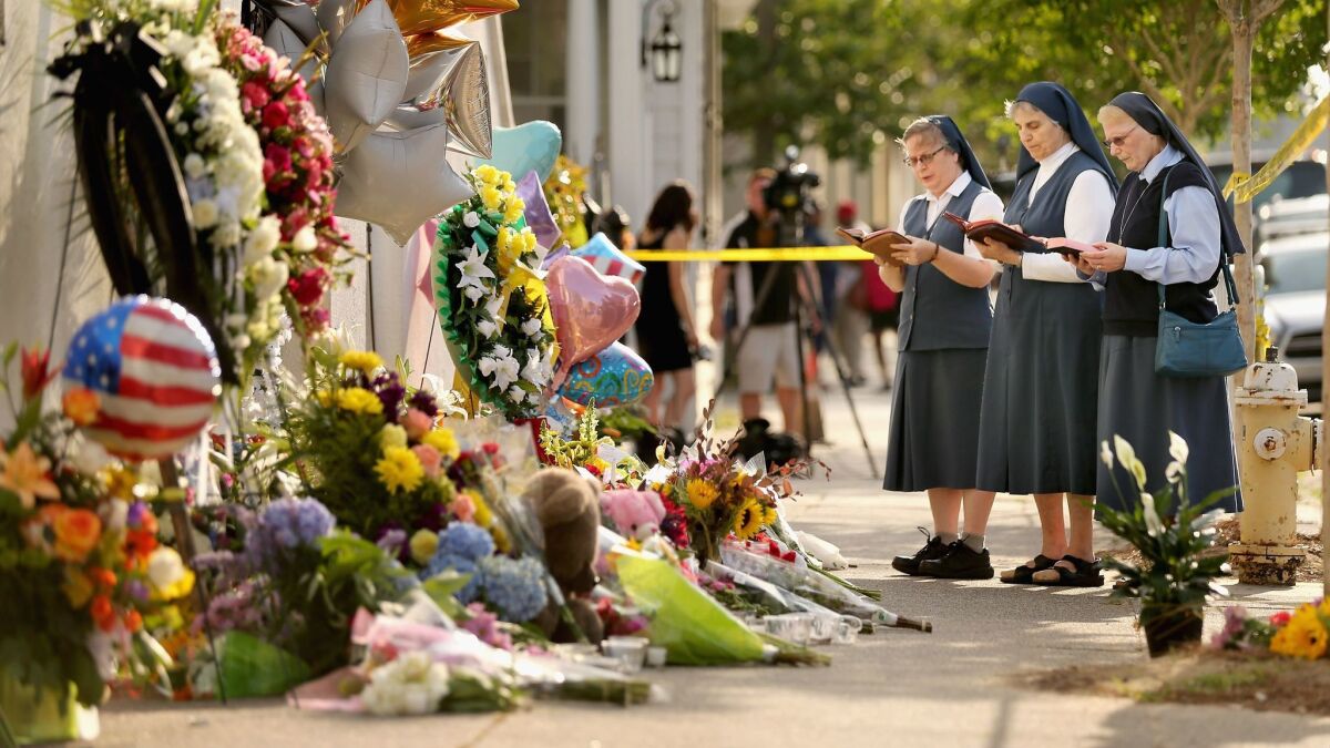 In this June 2015 photo, sisters of the Order of the Daughters of St. Paul pray outside the historic Emanuel African Methodist Episcopal Church in Charleston, South Carolina, where self-proclaimed white supremacist Dylann Roof killed nine people during a prayer meeting.
