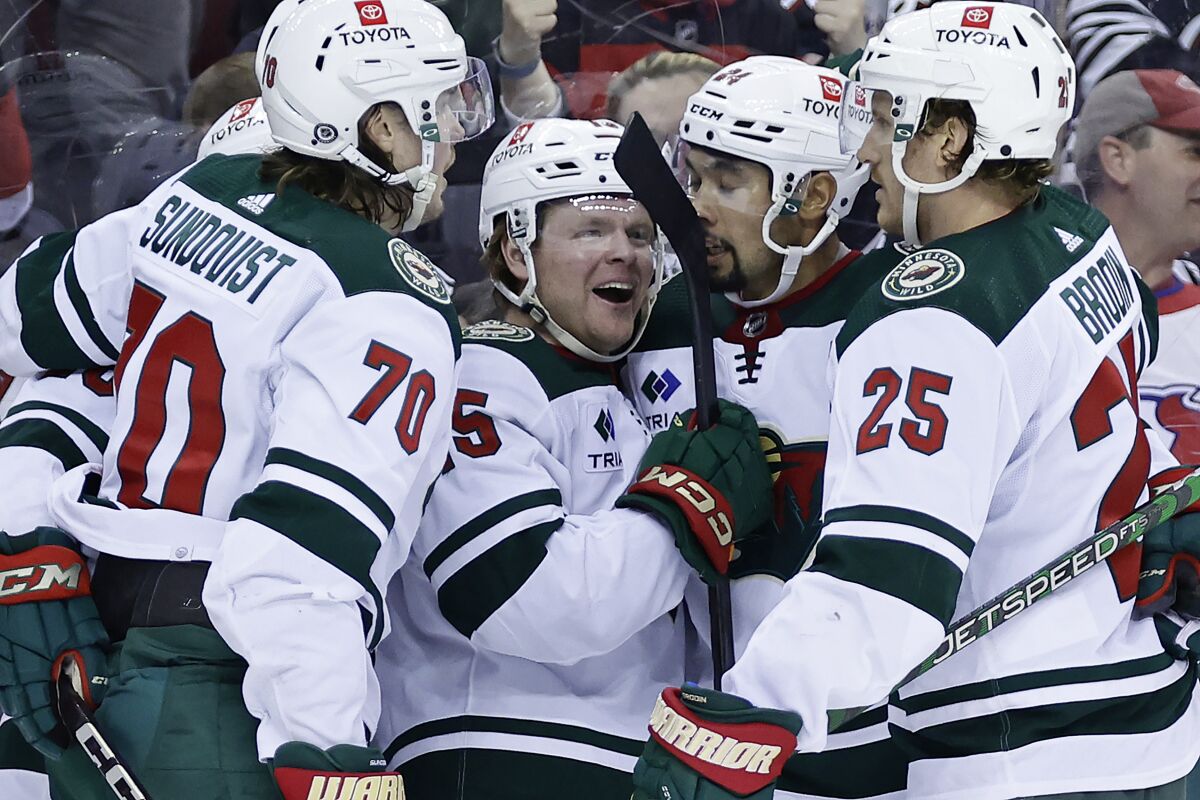 Minnesota Wild center Mason Shaw (15) celebrates with teammates after his goal against the New Jersey Devils during the third period of an NHL hockey game Tuesday, March 21, 2023, in Newark, N.J. The Wild won 2-1 in overtime. (AP Photo/Adam Hunger)