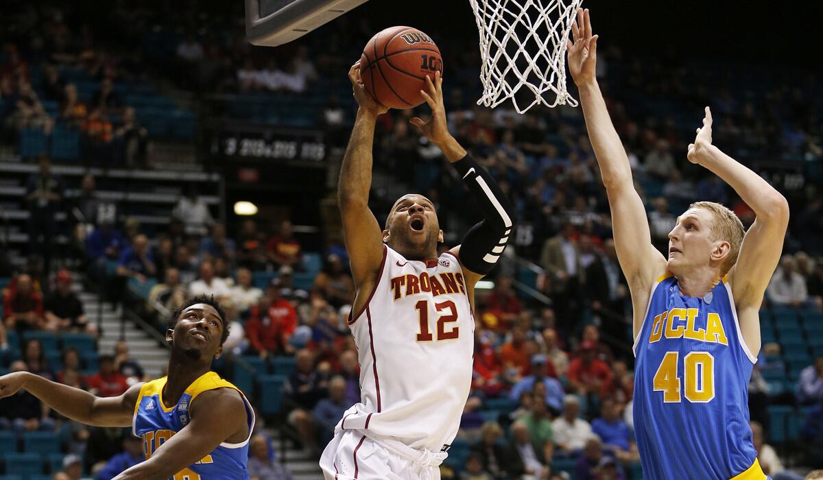 USC guard Julian Jacobs, center, shoots between UCLA guard Isaac Hamilton, left, and center Thomas Welsh during the first half of the first round of the Pac-12 men's tournament on Wednesday in Las Vegas.