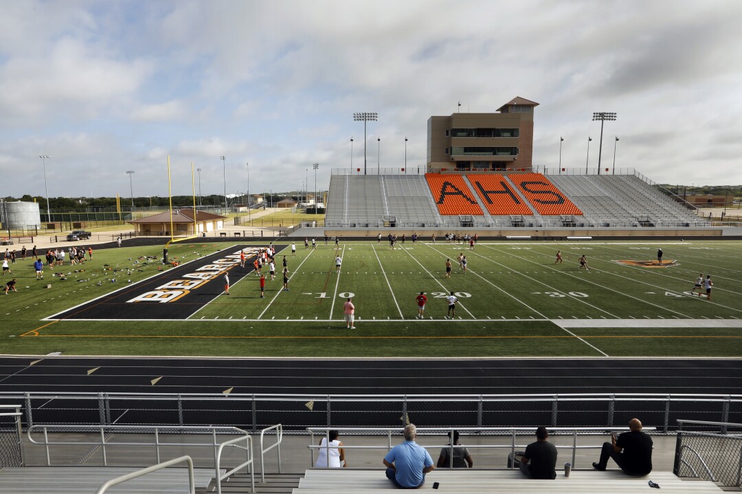 Parents watch from the stands, as their sons practice at Bearcat Stadium.