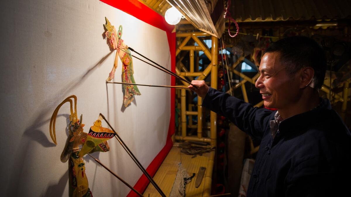 A man operates shadow puppets in Xuancheng, China. Shows have traditionally been performed in an ancient form of Chinese operatic singing.