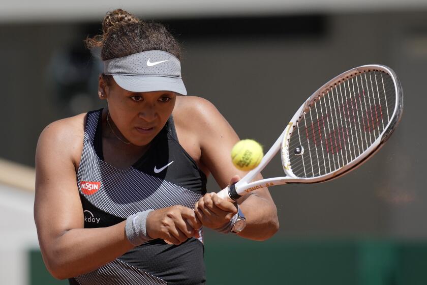 Japan's Naomi Osaka returns the ball to Romania's Patricia Maria Tig during their first round match of the French open tennis tournament at the Roland Garros stadium Sunday, May 30, 2021 in Paris. (AP Photo/Christophe Ena)