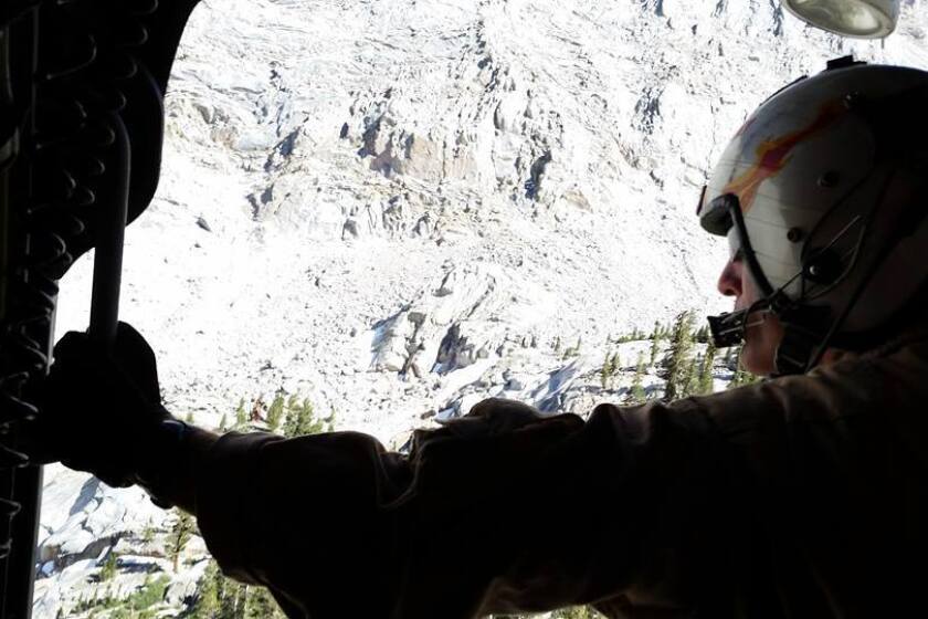 A member of an aerial crew peers out of a helicopter during the search for John Likely, a 60-year-old hiker who went missing on Mt Whitney.