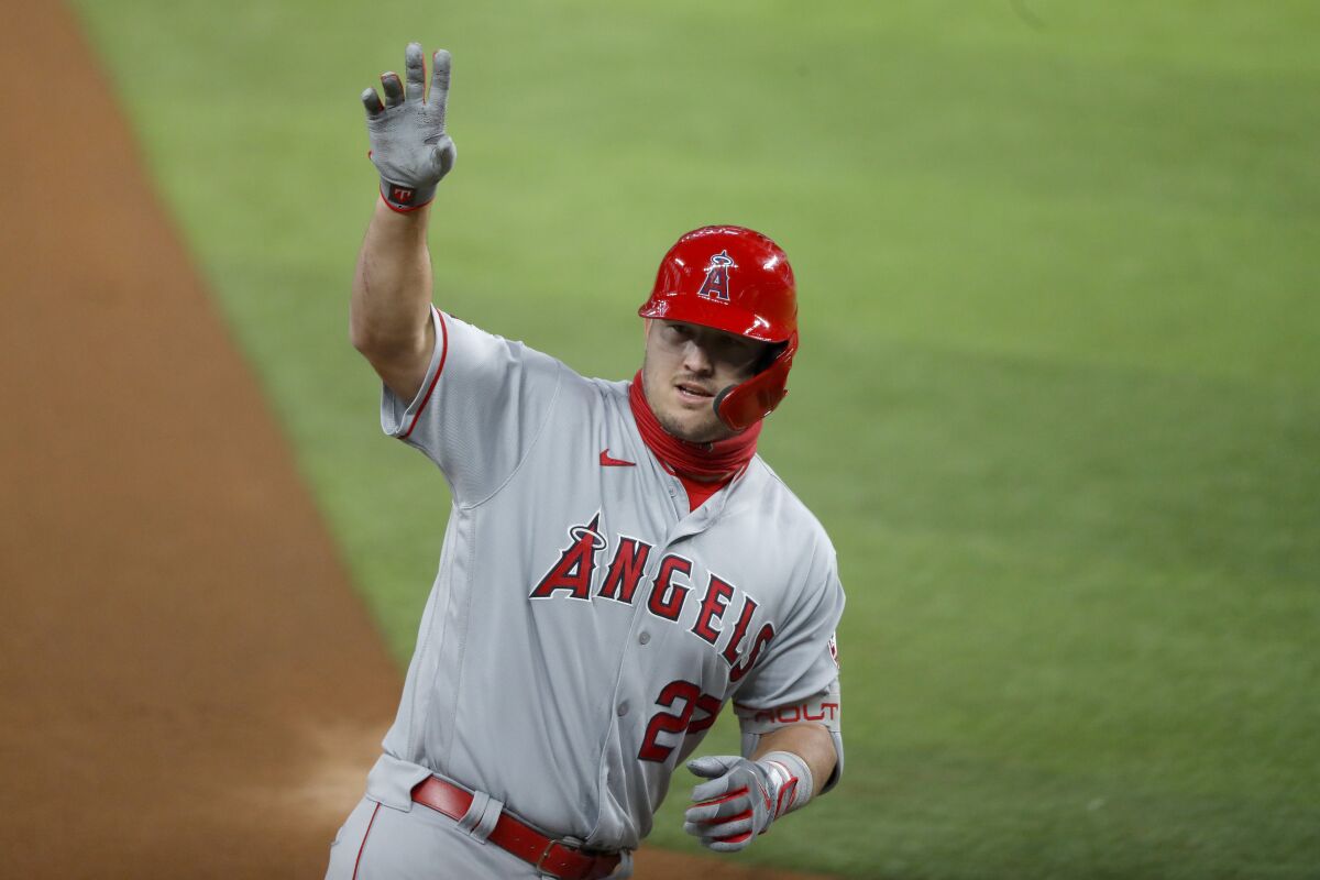 Los Angeles Angels' Mike Trout waves to the dugout after hitting a two-run home run in the first inning of a baseball game against the Texas Rangers in Arlington, Texas, Friday, Aug. 7, 2020. The shot scored David Fletcher. (AP Photo/Tony Gutierrez)