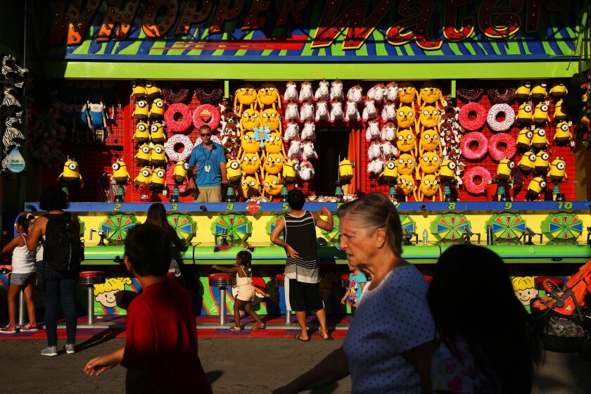 Fairgoers walk through the carnival game areas of the Los Angeles County fair in Pomona.