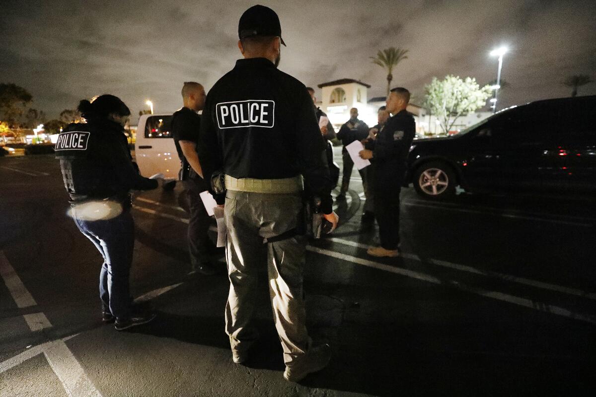 U.S. Immigration and Customs Enforcement officers during a pre-dawn briefing before apprehensions are made in Bell Gardens.