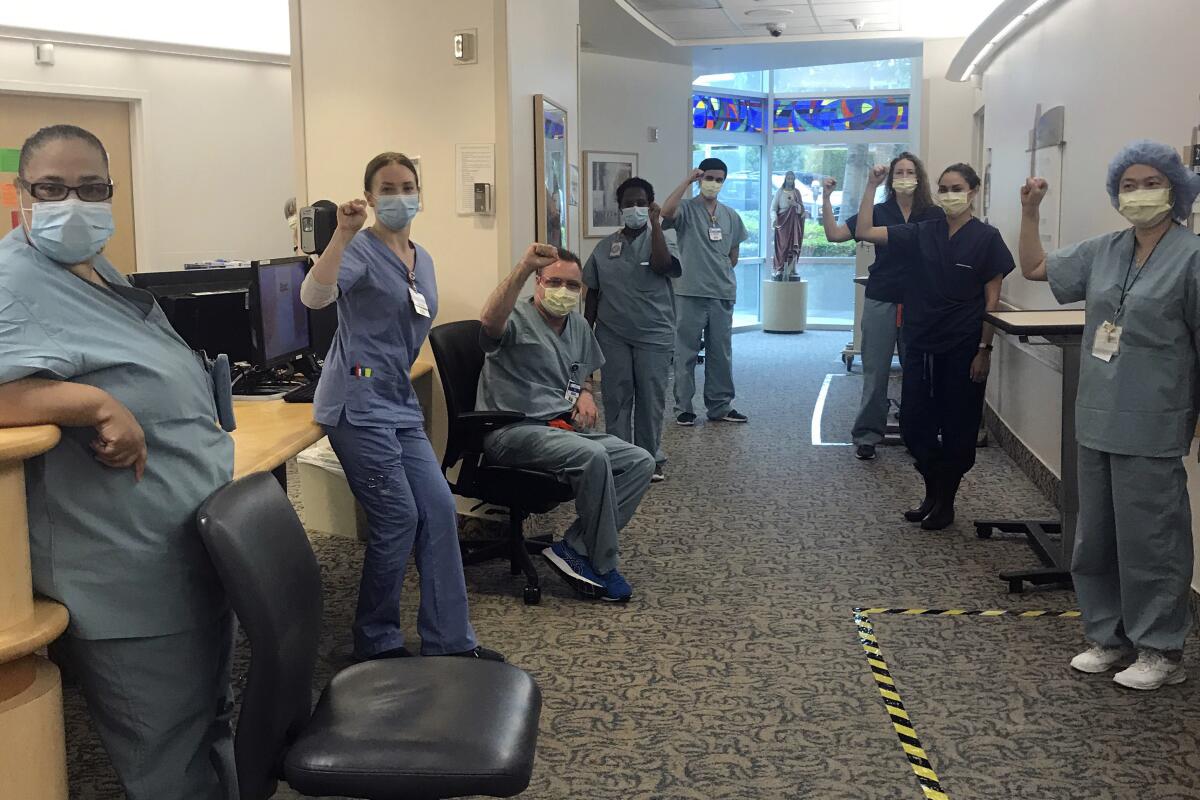 Nurses at Providence St. John's Health Center in Santa Monica raise their fists April 10 in solidarity after telling managers they can't care for COVID-19 patients without N95 masks.