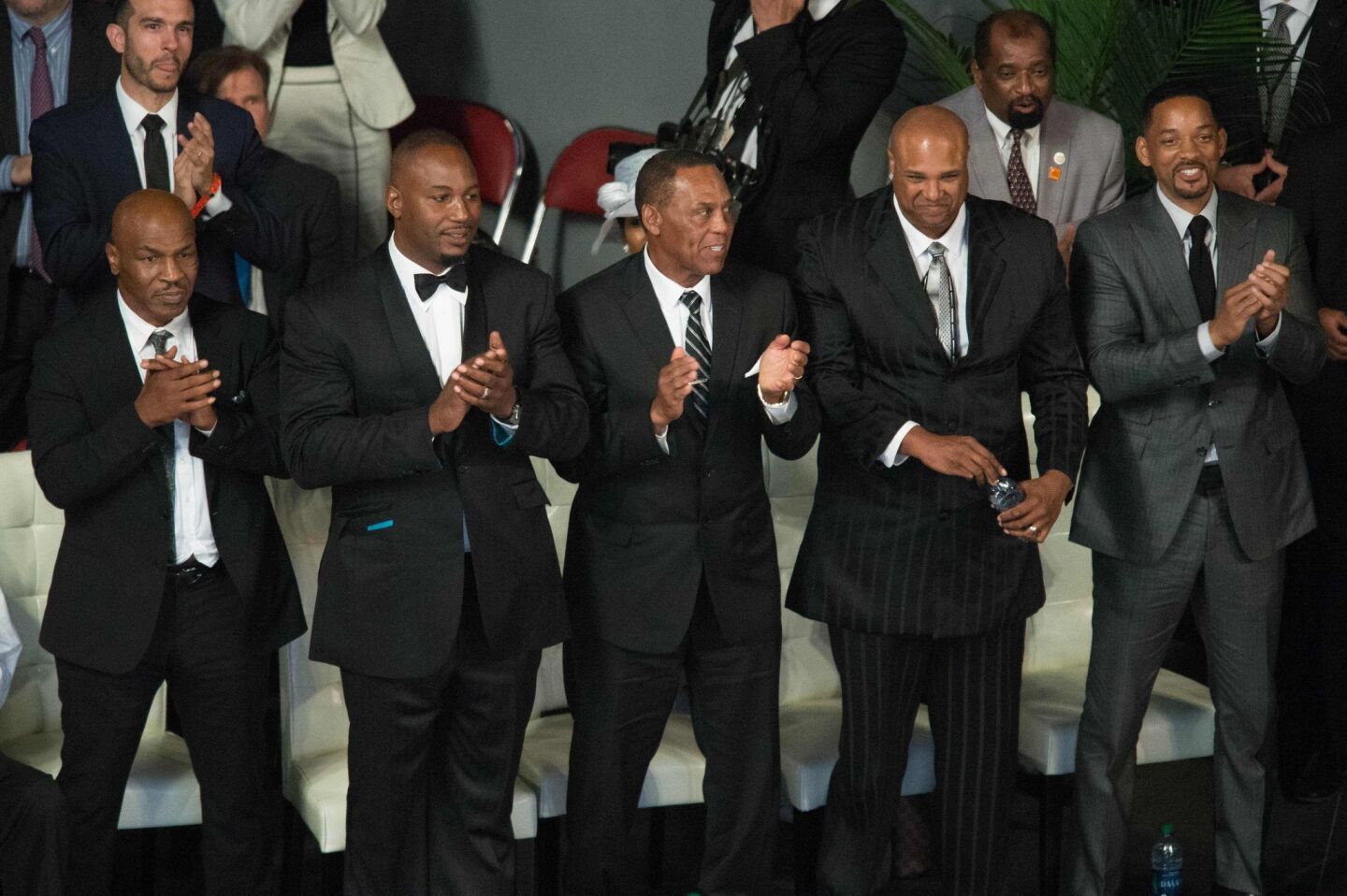 Pallbearers (from left) Mike Tyson, Lennox Lewis, Jerry Ellis, Mike Moorer and Will Smith applaud during a speech at the memorial service.