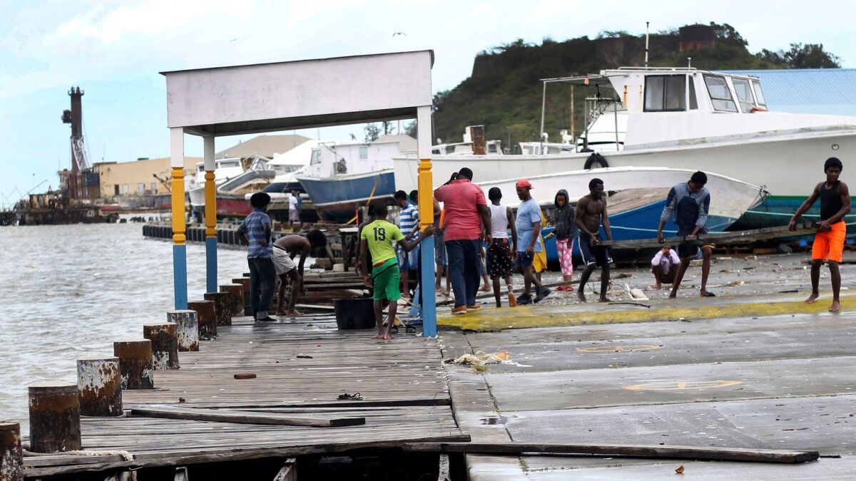 Debris is cleared from a damaged dock in St. John's, Antigua and Barbuda, after Hurricane Irma roared through on Wednesday.