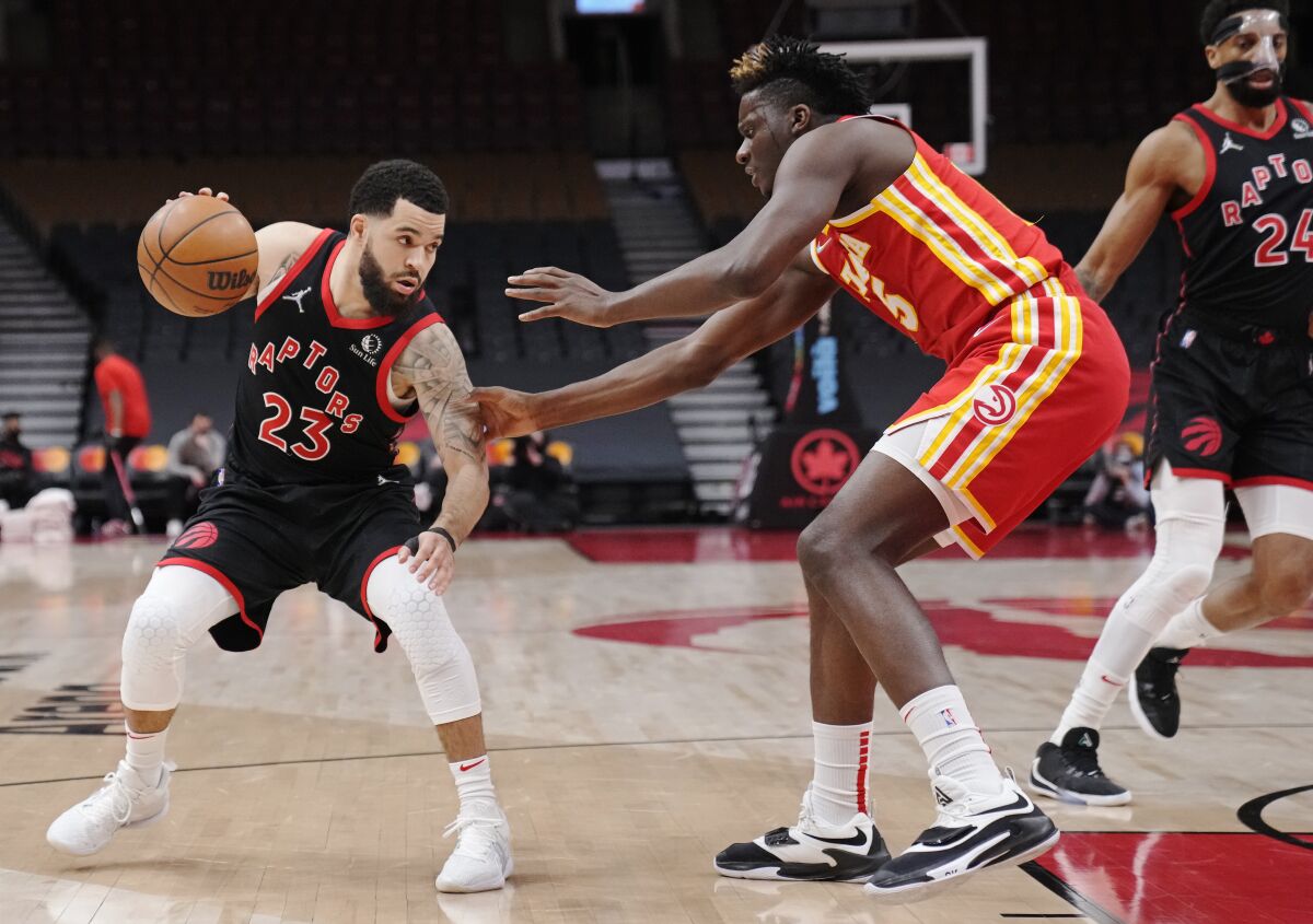 Toronto Raptors guard Fred VanVleet (23) protects the ball from Atlanta Hawks center Clint Capela (15) during the first half of an NBA basketball game Friday, Feb. 4, 2022, in Toronto. (Frank Gunn/The Canadian Press via AP)